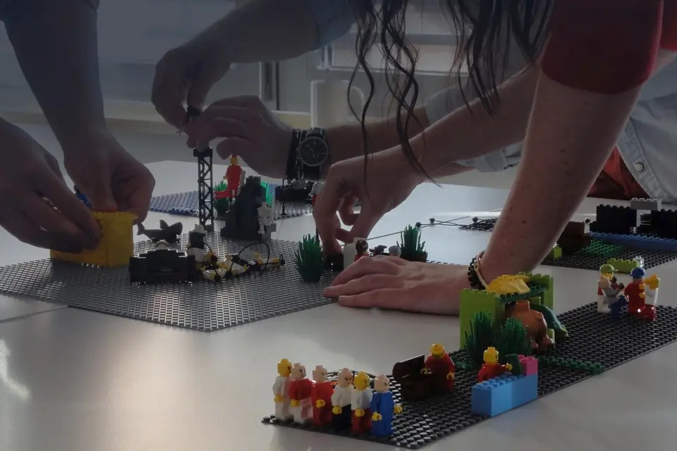 Mani al lavoro su modelli costruiti con i mattoncini LEGO durante una sessione di LEGO SERIOUS PLAY