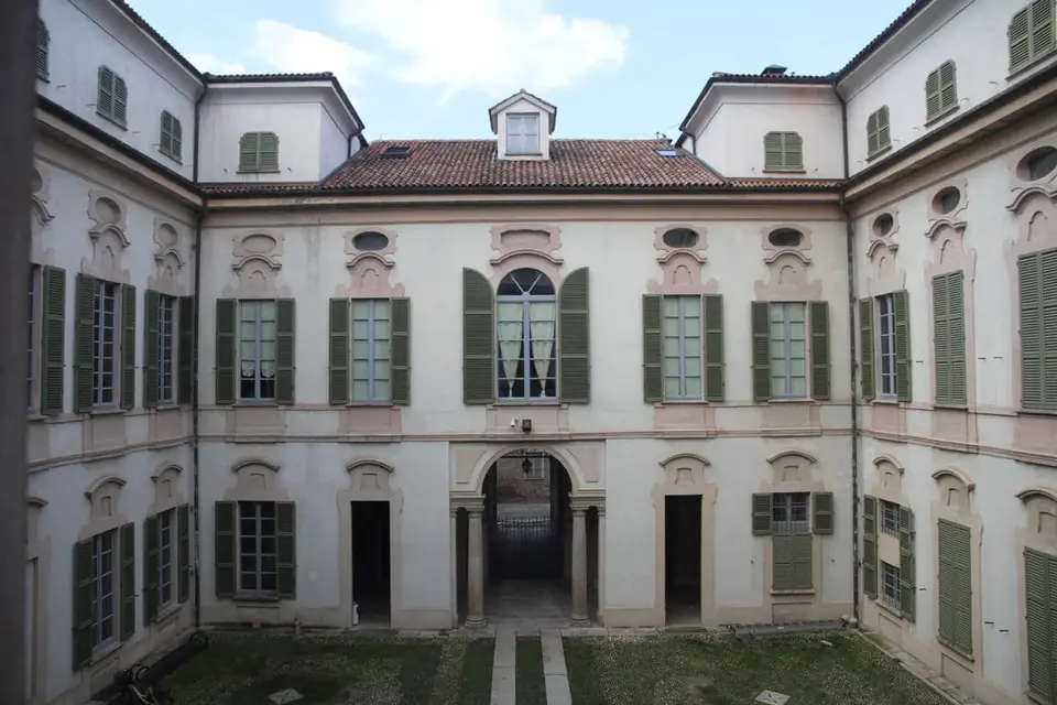 Il cortile interno di Palazzo Bellisomi-Vistarino, con le facciate chiare e le persiane verdi