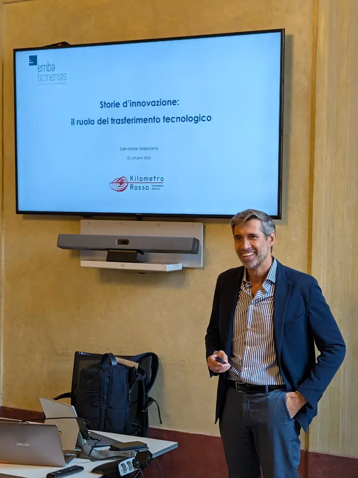 Salvatore Majorana in aula il 2 ottobre 2026, davanti alla slide della sua lezione «Storie d'innovazione: il ruolo del trasferimento tecnologico», con i loghi di EMBA Ticinensis e di Kilometro Rosso